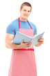A male chef holding a cookbook and looking at camera
