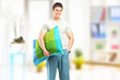 Smiling man in pajamas holding a pillow at home