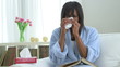 Sick African American woman blowing nose into tissue