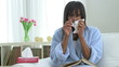 Black woman with cold blowing nose into tissue