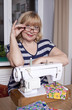 Old woman sews on the sewing machine