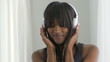 Black woman listening to earphones and smiling