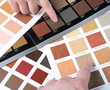 Hands pointing to sample color chart