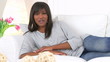 Happy black woman lounging on couch