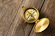 Antique compass over wooden background