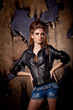 Girl with big hair posing over burned wall background