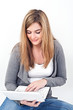 young woman working on laptop while sitting on the floor