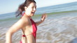 Woman Running Away From Camera On Beach