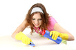Young housewife cleaning up table at home on grey background