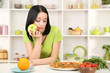 Foto: Pretty girl selects pizza or diet on kitchen background Pretty girl selects pizza or diet on kitchen background