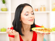 Girl with delicious pizza on kitchen background