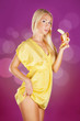 Photo: Cute blond woman holding a banana ready to eat over pink backgro Cute blond woman holding a banana ready to eat over pink backgro