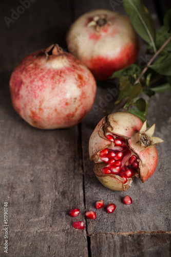 Photo: fresh pomegranate on wooden table. fresh pomegranate on wooden table.