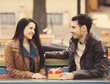 The young man gives a gift to a young girl in the cafe and they