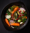 Fresh soup in a pot on black background