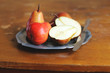 Fresh ripe pears in a plate with napkin and knife