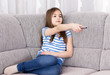 Cute little girl  watching tv on sofa