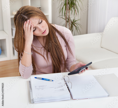 Photo: Young Woman Calculating Bills Young Woman Calculating Bills