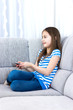 Cute little girl  watching tv on sofa