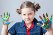 Photo: Beautiful little girl showing painted hands over grey background Beautiful little girl showing painted hands over grey background