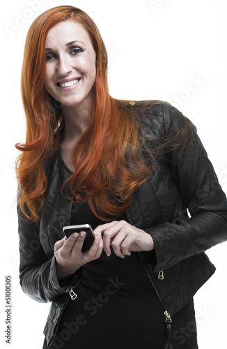 Photo: Smiling redhead woman using a mobile phone Smiling redhead woman using a mobile phone