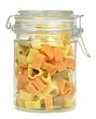 A glass jar of pasta hearts on a white background