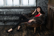 Studio portrait of a fashionable woman resting in a vintage room