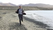 Young businessman jogging on the seashore with cellphone, slow m