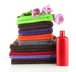 Pile of colorful towels and bottle of conditioner for laundry,