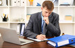 Photo: Young businessman in office at his workplace Young businessman in office at his workplace