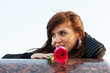 Happy young woman with a red rose