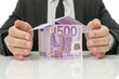Male hands around money house