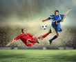 Photo: two football players striking the ball two football players striking the ball