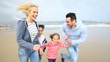 Family running on a sandy beach