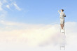Businesswoman standing on ladder