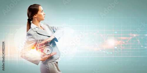 Photo: Business woman holding alarmclock Business woman holding alarmclock