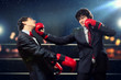 Two young businessman boxing