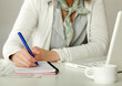 Photo: A woman at the desk writting on a paper A woman at the desk writting on a paper
