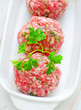 Raw meat balls in the white bowl