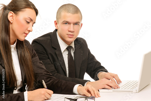 Photo: Businesspeople working at desk with a laptop, isolated on white Businesspeople working at desk with a laptop, isolated on white