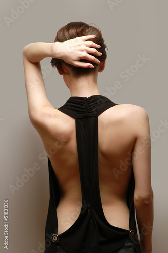 Photo: A beautiful woman, back view, isolated on brown background A beautiful woman, back view, isolated on brown background