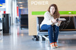 Thoughtful woman with electronic device near place to charge