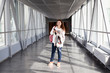 Young woman with mobile phone standing in airport hall