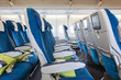 Comfortable seats in cabin of aircraft with screens in chairs