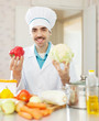Photo: Happy cook man in toque with vegetables Happy cook man in toque with vegetables