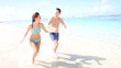 Vidéo : Couple running on a sandy beach Couple running on a sandy beach