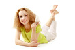 Smiling young woman lying on floor and showing