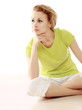 Photo: A young woman sitting on the floor A young woman sitting on the floor