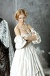 Photo: Woman in vintage dress sitting near retro sewing machine Woman in vintage dress sitting near retro sewing machine