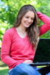 Smiling girl laptop in park